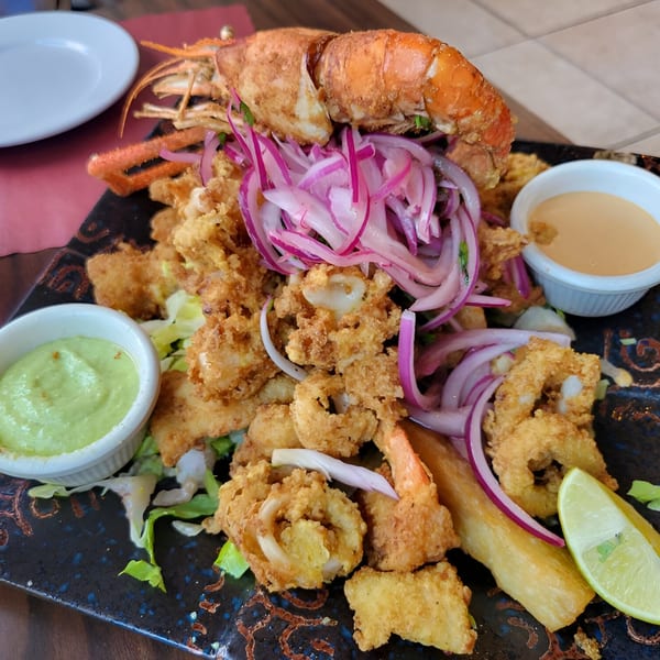 Peruvian seafood platter with fried calamari, shrimp, lobster, yucca, red onions, and two dipping sauces.